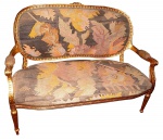 Sofá  dois lugares em madeira com douração com  estofamento em tapeçaria assinada. Med.: 1,01,27 x60 cm.