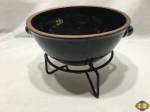 Panela de barro esmaltado sem tampa com suporte em ferro. Medindo a panela 23cm de diâmetro x 9,5cm de altura.