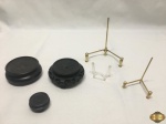Lote com 3 suportes para livro de mesa em materiais diversos e 3 peanhas em madeira. Medindo a peanha maior 7,5cm de diâmetro.