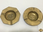 Lote de 2 cinzeiros em bronze com brasão no fundo. Medindo 14,5cm de diâmetro.