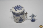 Lote composto de potiche e pequena boneca em porcelana holandesa azul e branco. Medindo o pote 9cm de altura.