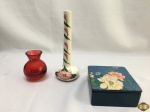 Lote composto de vaso solifleur em porcelana pintada, 1 pequeno vaso em vidro vermelho e caixa em cerâmica pintada. Medindo a caixa 13,5cm x 12,5cm x 5,5cm de altura.