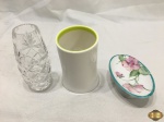 Lote composto de pequena salva com pé em porcelana, vaso floreira em cristal lapidado e porta treco em plastico duro. Medindo a floreira 12,5cm de altura.