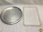 Lote de 2 bandejas, sendo uma redonda em alumínio e uma retangular em acrílico. Medindo a retangular 40cm x 28cm x 3cm de altura.