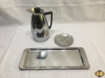 Lote composto de garrafa térmica, bandeja retangular e descanso de garrafa. Medindo a garrafa 23,5cm de altura.