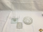 Lote composto de cinzeiro em vidro moldado, caixa na forma de presente em vidro moldado e floreira em vidro incolor. Medindo a floreira 30cm de altura.