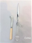 Lote de 2 facas em metal, sendo uma para cartas e a outra para queijos. O abridor de cartas com cabo em acrilico  lapidação bico de jaca, medindo 24cm de comprimento e a faca para queijo com cabo em baquelite, lamina em aço inox Hércules, medindo 14cm de comprimento.