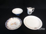 Lote 4 peças em porcelana composto por leiteira, petisqueira, e pires. Leiteira: 8cm de altura x 4cm de diametro de boca, petisqueira 5cm de altura x 12cm de diametro, o pires com desenho de cozinheiro com 14cm de diametro e o prato porcelana renner medindo 17cm de diametro. A petisqueira e o pires apresentam pequenos bicados.