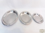 Lote de 3 travessas ovais em aço inox decorada com flores em relevo. A maior medindo 34x22cm de comprimento, a média 25x18,5cm e a menor 21x14cm.