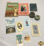 Lote com diversos missais, santinhos e 2 caixas decorativas. Medindo a caixa redonda em metal esmaltado 6,5cm de diâmetro x 3,5cm de altura.