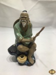 Escultura de sábio oriental pescando em porcelana com rica policromia. Medindo 14,5cm de altura.
