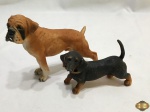 Lote de 2 enfeites de cachorro em resina, sendo um bulldog e um basset. Medindo o bulldog 16,5cm de comprimento x 13,5cm de altura.