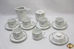 Jogo de chá com 8 peças em porcelana Schmidt floral. Composto de 6 xícaras, 5 pires, 1 manteigueira, 1 açucareiro e 1 leiteira. Algumas peças com bicado.