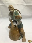 Escultura de pescador oriental em porcelana vitrificada. Medindo 17,5cm de altura.