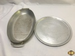 Lote composto de travessa oval com alça e bandeja em alumínio. Medindo a travessa 37,5cm x 23,5cm x 5cm de altura.