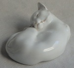 Escultura formato de gato em repouso elaborado em porcelana branca, (com filetes em ouro.  comprimento  15cm. Marca do Fabricante na base. (CSA)