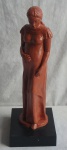 Arte Popular - Escultura de Barro representando mulher  grávida em seu vestido  longo, peça assinada e com base em madeira na tonalidade escura.  MED: 46 X 20 X 16 CM
