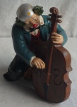 Escultura de palhaço sentado na banqueta tocando Violão Celo, elaborado em resina Italiana, com rica policromia. Alt.26cm x 20cm de base.