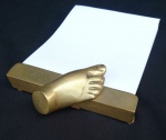 PIETRINA CHECCACCI - Porta bloco em bronze, com pegador no formato de pé. Assinado. Med.: 17 X 6 cm.