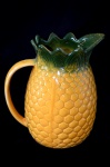 Grande jarra em cerâmica vitrificada no formato de abacaxi, nos tons de amarelo e verde. Med.: 22 X 20 cm.