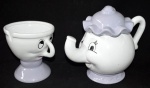 Imponente conjunto em porcelana branca, sendo: 1 bojudo bule para chá, representando "Mrs Potts" e xícara, representando "Chip" do filme A Bela e a Fera, da Disney. Med. bule: 25 X 20 cm.; e Med. xícara: 15 X 14 cm.