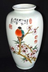 Vaso em porcelana chinesa no tom branco, decorado com cena de pássaro sobre galhos. Apresenta inscrições e selo vermelho. Med.: 32 X 16 cm.