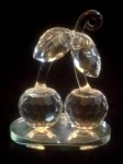 Excepcional grupo escultórico em cristal translúcido  atribuído a cristaleria austríaca Swarovisk ricamente lapidado, representando cerejas. Base espelhada. Em perfeito estado. Med.: 12 X 9,5 cm.