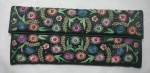 Bolsa de mão estilo carteira, confeccionada em tecido no tom preto, com bordados florais em policromia e rebordados com miçangas e paetês. Med.: 21 X 12 cm.
