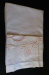 Conjunto para cama de solteiro, em linho no tom branco, com bordados em tons de amarelo, laranja e vermelho, composto por: Lençol e 1 fronha. Marcas de guardado. Med. lençol: 2,30 X 1,55 cm.
