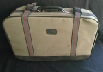 Antiga mala de viagem em material sintético no tom cáqui, com presilhas em lona. Marcas do tempo. Med.: 60 X 16 X 41 cm.