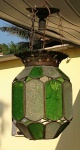 Antiga luminaria sextavada no feitio de lanterna. Vidros crespos em tons de verde e branco. Avista-se perda de um vidro. Med.: 52 X 27 cm.