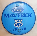 Quadro no estilo vintage, confeccionado sobre tampa de tambor, em ferro, com dizeres: "Ford Maverick", na cor azul. Med. total: 59 cm de diâmetro.