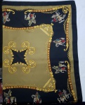 Lenço italiano em seda, no padrão estampado, em tons de preto, cáqui e amarelo, com figuras de cavaleiros. Med.: 78 X 78 cm.