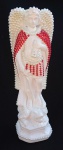 Imaginária em gesso, representando São Miguel Arcanjo, adornado com pérolas e pedrarias no tom vermelho. Med.: 21 X 8 cm.