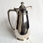 Elegante Jarra Inglesa em metal espessurado à prata da manufatura Mappin & Weeb, estilo Art Noveau. Faixa estilizada no gargalo, borda ondulada, tampa com pega. Bojo com selo em baixo relevo, marca de autenticidade no fundo. Exemplar antigo e em excelente estado de conservação. Dimensões: 27 cm altura x 15 cm diâmetro. Capacidade para 1,5 L.
