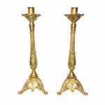 Arte Sacra - Suntuoso e antigo par de tocheiros em bronze polido. Base robusta,  ricamente decorada, apoiada por três pés recurvos no formato de folhas. Haste alongada  terminada com bobeche e copo para vela de até 3 cm de diâmetro. Ricos detalhes incrustados no formato de arabescos e folhas de acanto por todo o exemplar. Excelente estado de conservação.Dimensões: 46 cm altura. Base com 16 cm de largura.Peso aproximado 6 kg.