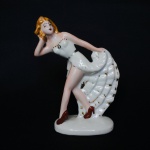 Estatueta de coleção em fina porcelana esmaltada representando "Dançarina dos anos 30". Exemplar antigo e em excelente estado.  Dimensões: 15,5 cm x 11,5 cm x 5 cm.