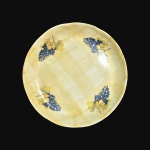 Grandiosa e antiga fruteira em cerâmica, formato circular, decorada com cachos de uvas sobre fundo amarelo. Exemplar em excelente estado de conservação. Dimensões: 45 cm x 7 cm.