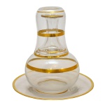 BACCARAT - "Verre d'eau" em cristal francês decorada com frisos em ouro. França. Séc. XX. 16 cm (moringa), 10 cm (copo) e 19 cm (prato).
