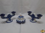 Lote composto de caixa redonda facetada e par de castiçais duplos em porcelana azul e branco. Medindo o castiçal 22cm de comprimento x 12,5cm de altura.