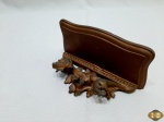 Peanha de parede em madeira entalhada com patina de ouro velho. Medindo 19cm x 9,5cm x 9cm de altura.
