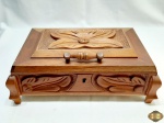 Caixa retangular em madeira ricamente entalhada, com divisões removíveis internas, interior e tampa revestido em veludo vermelho. Medindo 35cm x 24,5cm x 13,5cm de altura. Com fechadura, não acompanha a chave.
