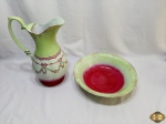Enorme gomil em porcelana com pintura verde com guirlanda floral. Medindo a jarra 39,5cm de altura e a bacia 36,5cm de diâmetro x 8,5cm de altura.