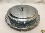 Suporte com pirex redondo com tampa em metal prateado Aurea com relevos. Medindo o pirex 26,5cm de diâmetro x 6cm de altura.