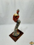 Escultura de mulher sob base em madeira com rica policromia, assinada Aurea Maria. Medindo 44cm de altura.
