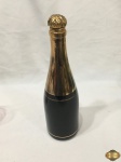 Garrafa licoreira na forma de garrafa de champanhe em vidro preto com ouro. Medindo 26,5cm de altura.