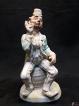 Escultura De Palhaço Sentado Porcelana C/ Policromia. MEDINDO: 22CM DE ALTURA