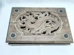 Caixa retangular em madeira com dragão esculpido e detalhes em madrepérola. Medindo 42cm x 29cm x 10cm de altura. Com uma rachadura na tampa.
