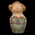 NENÊ CAVALCANTI  "Boneca de Roupa Azul". Escultura de barro policromado. 17 x 10 x 9 cm. Maria das Neves Cavalcanti Moreira, mais conhecida por Nenê Cavalcanti, nasceu em Alagoa Nova, interior da Paraíba. Foi à capital para estudar e formou-se primeiro em Enfermagem e depois em Pedagogia, mas o que definiu seu destino profissional foi o curso de Educação Artística, a partir do qual passou a dedicar-se exclusivamente às artes plásticas. Em suas esculturas em argila utiliza materiais como pregos, parafusos, arames farpados, molas, pedras semipreciosas, porcelanato, com um resultado bastante original. Nenê busca também no barro uma forma natural de colorir suas peças, pois sua queima em um forno específico para cerâmica faz com que ele mude de tonalidade e se transforme em tons de vermelho, branco, amarelo, rosa etc. Os temas recorrentes em sua obra são as mulheres e os anjos. Suas obras são encontradas em diversas regiões do país, tendo a artista participado de inúmeras exposições.