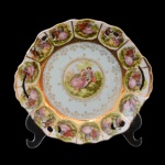 Covilhete em porcelana europeia com representação de cena galante ao centro. Detalhes em dourado e borda recortada, com iguais representações de cenas galantes por toda a volta. 20,5 cm.